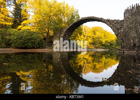 Bad Muskau, Deutschland. 29 Sep, 2017. Die Rakotz Brücke und Bäume im Herbst Farben werden in einem See in einem Park in Bad Muskau, Deutschland, 29. September 2017 wider. Credit: Monika Skolimowska/dpa-Zentralbild/dpa/Alamy leben Nachrichten Stockfoto