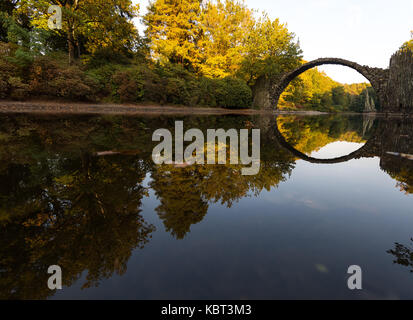 Bad Muskau, Deutschland. 29 Sep, 2017. Die Rakotz Brücke und Bäume im Herbst Farben werden in einem See in einem Park in Bad Muskau, Deutschland, 29. September 2017 wider. Credit: Monika Skolimowska/dpa-Zentralbild/dpa/Alamy leben Nachrichten Stockfoto