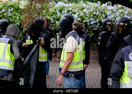 Barcelona, Spanien. 1. Oktober 2017. Hunderte Polizisten gehen zu einem Wahllokal, nehmen die Wahlurnen und werfen sie in einen Müllsack. Hunderte von Menschen versuchen zu wählen, wenn Dutzende von Polizisten in Heizung Menschen brechen, um die Wahlurnen nehmen, um sie in einen Müllsack. Mehrere friedliche Menschen wurden verletzt. Quelle: Victor Turek/Alamy Live News Stockfoto