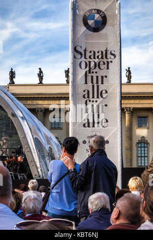 Berlin. Deutschland, 30. September 2017. Menschenmassen versammeln sich am Bebelplatz in Unter den Linden für die Kostenlose jährliche Staatsoper Open Air Konzert unter der Leitung von Daniel Barenboim. Dieses Jahr 2017 Open-air-Konzert markierte die Wiedereröffnung des Staatlichen in der Staatsoper Unter den Linden. Das Orchester der Staatsoper Berlin Ludwig van Beethovens Symphonie Nr. 9 (Symphonie "Ode an die Freude"). Auf eine vorübergehende Phase. Die Straße war zu Verkehr und Berlinern und Touristen geschlossen zu dem Konzert mit zusammenklappbaren Stühlen und Picknickkörbe beflockt. Credit: Eden Breitz/Alamy leben Nachrichten Stockfoto