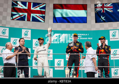 Lewis Hamilton (L) von Mercedes, Max Verstappen (C) und Daniel Ricciardo (R) von RBR TAG Heuer feiern ihren Sieg in der F1 Grand Prix auf dem Sepang F1 Circuit. Verstappen beendete das Rennen in der ersten Position, Hamilton kam an zweiter Stelle und Ricciardo gewann den 3. Platz. Am 01. Oktober 2017 in Kuala Lumpur, Malaysia. Stockfoto