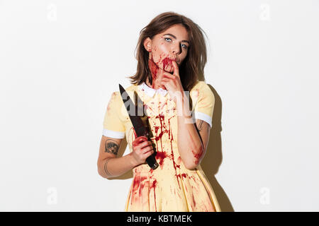 Creepy zombie Frau in Blut Flecken mit einem Messer, und wenn man die Kamera auf weißem Hintergrund abgedeckt Stockfoto