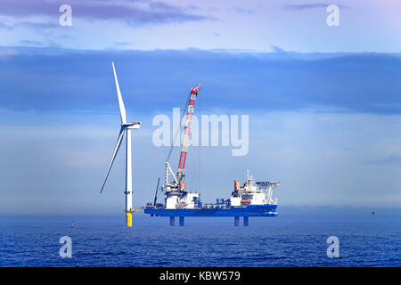 Whitley Bay St Marys Leuchtturm mit der barge Vole-au-Vent der Installation von Offshore- Windenergieanlagen in der Neptun Werft gemacht Stockfoto