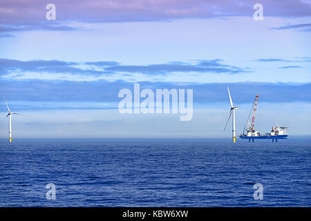 Whitley Bay St Marys Leuchtturm mit der barge Vole-au-Vent der Installation von Offshore- Windenergieanlagen in der Neptun Werft gemacht Stockfoto