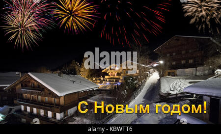 Vorabend des neuen Jahres mit alpinen Dorf im Schnee, Feuerwerk, russische Begrüßungstext Stockfoto