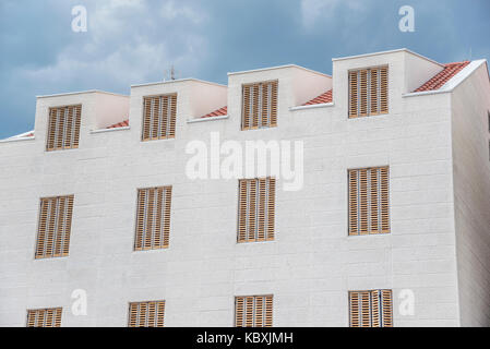 Weißes Gebäude mit wunderschönen Fenstern. Stockfoto