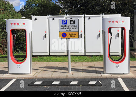 Tesla Elektroautos Ladestationen mit Schaltkästen hinter, Hopwood Autobahn Dienstleistungen, Alvechurch, Birmingham Stockfoto