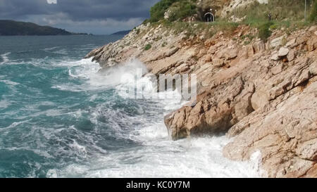 Die Wellen auf einem steinigen Strand brechen, bilden ein Spray. Filmmaterial. Plätschernden Wellen auf die Felsen auf das Meer Stockfoto