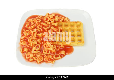 Alphabet Spaghetti und eine Kartoffel Waffel auf einer Platte gegen Weiße isoliert Stockfoto