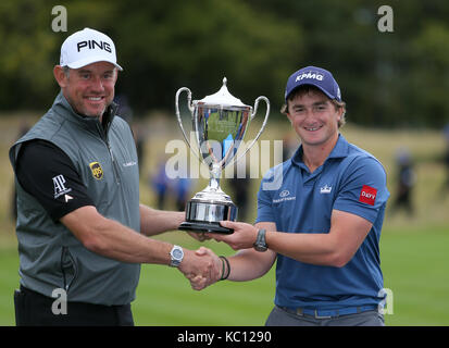 Irlands Paul Dunne schüttelt Hände mit der Engländer Lee Westwood, als er die Trophäe bei Tag vier der britischen Meister erhält in der Nähe House Golf Club, Newcastle. Stockfoto