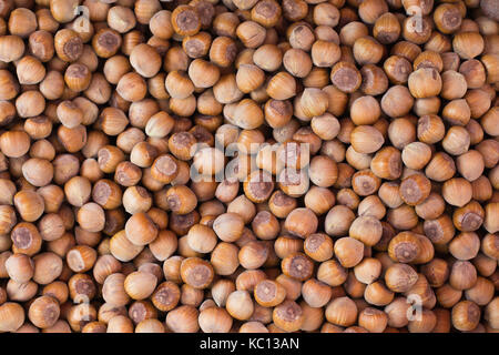 Haselnüsse Braun Muttern Hintergrund, frischen Nüssen Haufen mit Shell auf der Farmers Market, natürliche gesunde Nahrung Flachbild von oben legen Stockfoto