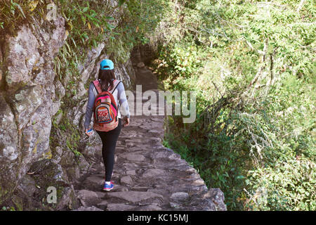 Frau auf dem Inka Trail Ansicht von hinten. Mädchen mit Rucksack auf Wanderweg Stockfoto