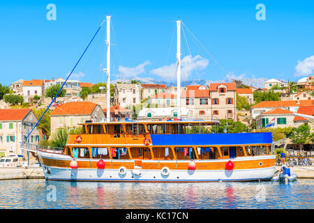 Touristische Segelboot in sumartin Hafen mit bunten Häuser im Hintergrund, Insel Brac, Kroatien Stockfoto