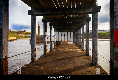 Unter dem Abschnitt unterhalb der West Pier Erweiterung gebaut zwischen den Jahren 1908 und 1914 an der Hafeneinfahrt, mit Whitby Abbey und eine der Leucht Stockfoto