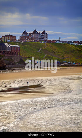 Einsame Wanderer auf der North Beach übersehen durch die Metropole Luxury Apartments im Stadtteil West Cliff von Whitby, Yorkshire, England Stockfoto