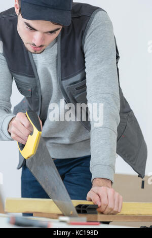 Hand sägen ein Stück Holz Stockfoto