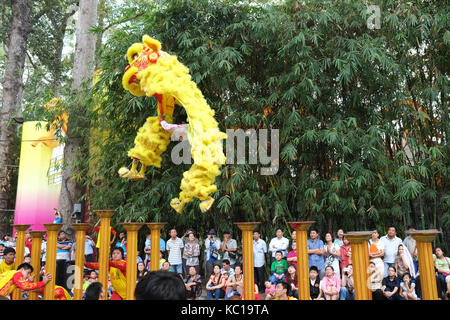 Saigon - Feb 03, 2014: Lion dancing auf Blume Säulen (Mai Hoa Thung) bei Tao Dan Park, Ho Chi Minh City, Vietnam am Neujahrsfest. Stockfoto