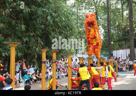 Saigon - Feb 03, 2014: Lion dancing auf Blume Säulen (Mai Hoa Thung) bei Tao Dan Park, Ho Chi Minh City, Vietnam am Neujahrsfest. Stockfoto