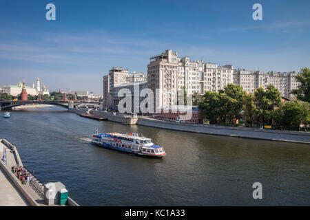 Ein Schiff auf dem Fluss Moskwa in der Nähe von Kreml Sofiyskaya Damm, mit Türmen und die Türme des Doms im Hintergrund, Moskau, Russland. Stockfoto