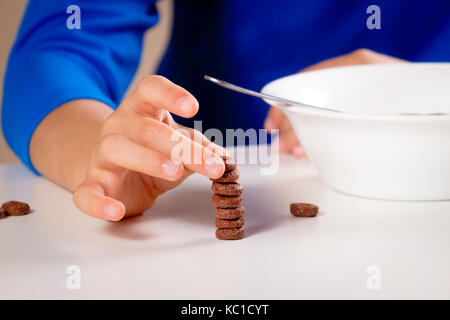 Nahaufnahme der Hand von Kid Essen hausgemachtes Müsli zum Frühstück oder Mittagessen. Stockfoto