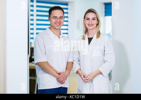 Zwei männliche und weibliche Ärzte oder Krankenschwestern stehen innen Krankenhausgebäude. Stockfoto