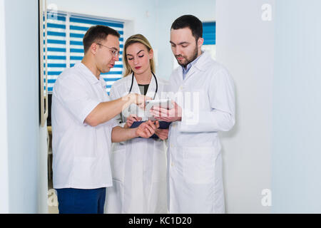 Hohe Betrachtungswinkel von drei Ärzte in weißen Kitteln in Gespräch am Krankenhaus Halle Stockfoto