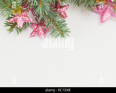 Rosa sternförmigen Ornamente hängend an einer Tanne Zweig. Weihnachtsfeier Zeit. Stockfoto