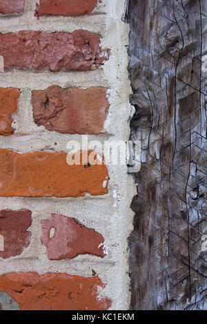 Alten Ziegel Wand neben der Hand gehauenen alten Holz. Stockfoto