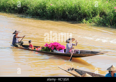 Frauen und junge verkaufen Pink Lotus Blumen aus Ruderboot am Inle See Stockfoto