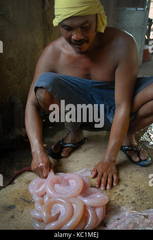 Mann Reinigung Darm von einem Schwein, Angeles, Philippinen. Stockfoto