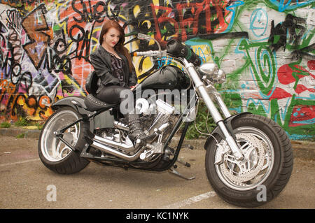 Hübsches Mädchen auf eine benutzerdefinierte chopper Motorrad in der Stadt liegt, Stockfoto