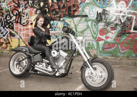 Hübsches Mädchen auf eine benutzerdefinierte chopper Motorrad in der Stadt liegt, Stockfoto