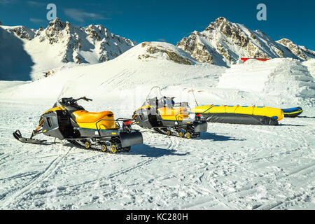 Fantastische Winterlandschaft mit gelben Motorschlitten in der berühmten Fagaras Gebirge in der Nähe von gefrorenen Balea See, Karpaten, Siebenbürgen, Rumänien, Europa Stockfoto