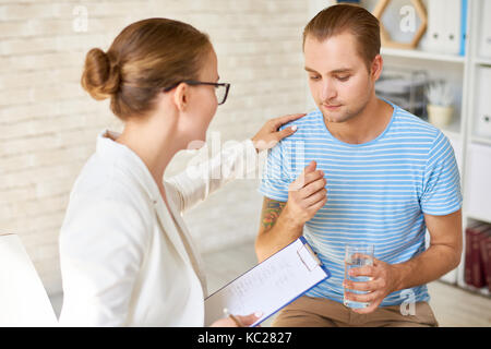Portrait von weiblichen Psychiater tröstet weinende junge Mann während der therapiesitzung, die Beratung und Unterstützung bei psychischen Problemen Stockfoto