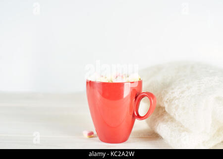 Rot Tasse Kaffee auf weiße Holztisch neben Strickwaren. kopieren. Stockfoto