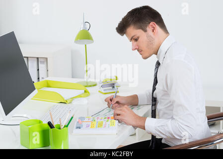 Junge Unternehmer Arbeiten an Gantt-diagramm in die Vorderseite des Computers an der Rezeption Stockfoto