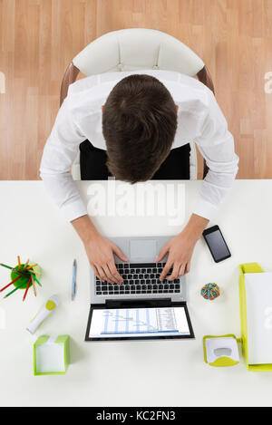 Hohe Betrachtungswinkel des Geschäftsmanns, der auf dem Laptop zeigt das Gantt-diagramm am Schreibtisch Stockfoto