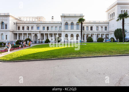 LIVADIYA, Krim - 21. SEPTEMBER 2017: Volk und Vorderansicht des Grand Liwadia-palast. Der Palast war die Sommerresidenz der russischen Kaiser fam Stockfoto