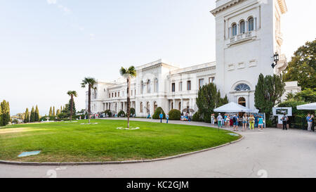 LIVADIYA, Krim - September 21, 2017: Touristen in der Nähe der Fassade des Grand Liwadia-palast. Der Palast war die Sommerresidenz der russischen Kaiser fami Stockfoto