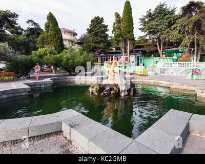 Aluschta, Krim - September 21, 2017: Touristen in der Nähe von Brunnen Junge mit Fisch auf Lenin Street Damm in Aluschta am Morgen. Aluschta ist Seaside Resort Stockfoto