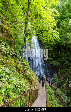 Düzce, Türkei - 29. APRIL 2017: Blick auf Guzeldere Wasserfall Musikberieselung aus hohen Felsen mit Menschen zu Fuß auf Holz- Pfad. Stockfoto