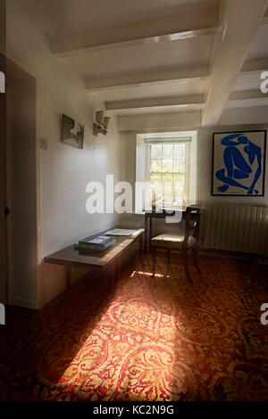 Uriges Haus Innenraum; Zimmer mit Schatten und sonnendurchfluteten Fenstern. Alt fühlen und durcheinandergeworfen Zimmer mit Stühlen, Bücher, CD's und Haus halten. Stockfoto