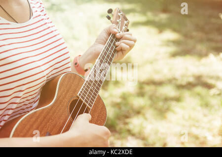 Anonyme Frau spielen Ukulele Stockfoto