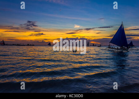 Boracay, Philippinen - 16 Sep 2015: Silhouette von Segelbooten und Menschen bei Sonnenuntergang auf White Beach von Boracay, Philippinen Stockfoto
