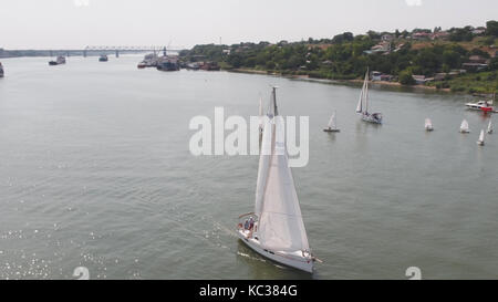 Tankschiff und Segelboot auf dem Fluss. Luftaufnahme. Segelboote und ein Tankschiff Stockfoto