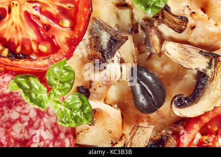 Nahaufnahme von Pizza mit Salami, Tomaten und Oliven Stockfoto