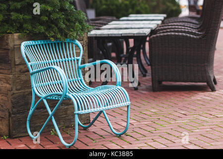 Vintage Design Möbel des Restaurants im Freien. Blau Korbstuhl und Holztisch Stockfoto