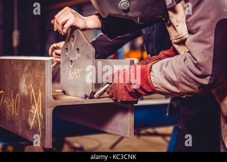 Industrielle Schweißer mit Taschenlampe Vorbereitung zum Schweißen von Metall Profile Stockfoto