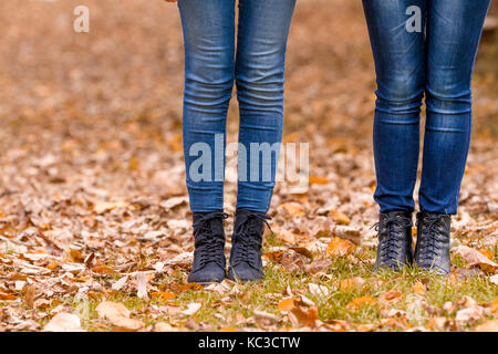 Girls Feet stiefel Wandern auf Herbstlaub im Freien mit Herbst Jahreszeit Natur auf Hintergrund Stockfoto