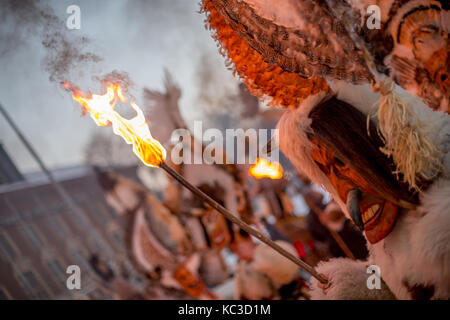 Pernik, Bulgarien - Januar 27, 2017: Maskierte männliche Teilnehmer in Scary Fell Kostüm und Maske ist die brennende Fackel an surva, der Internationalen Stockfoto